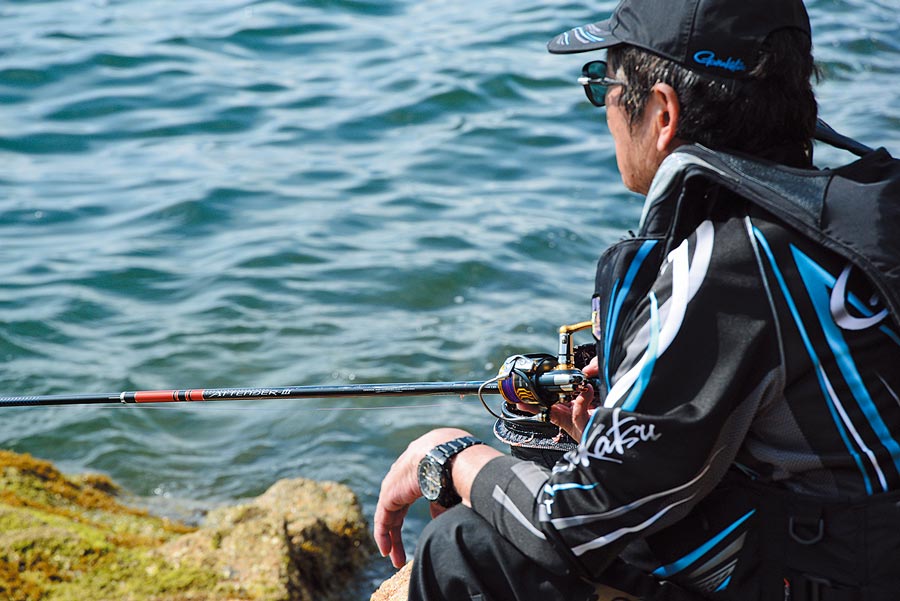 アテンダーⅢを手に海に臨む松田