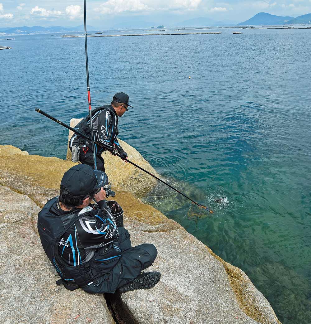 チヌを海面に浮かせた松田と、それをタモ入れする圓山