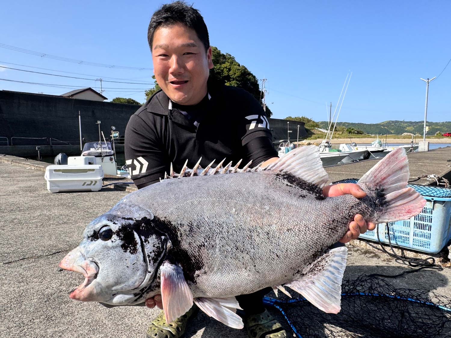 釣り上げたクチジロ83.5cmを両手に持ち満面の笑みを見せる富樫憲哉様