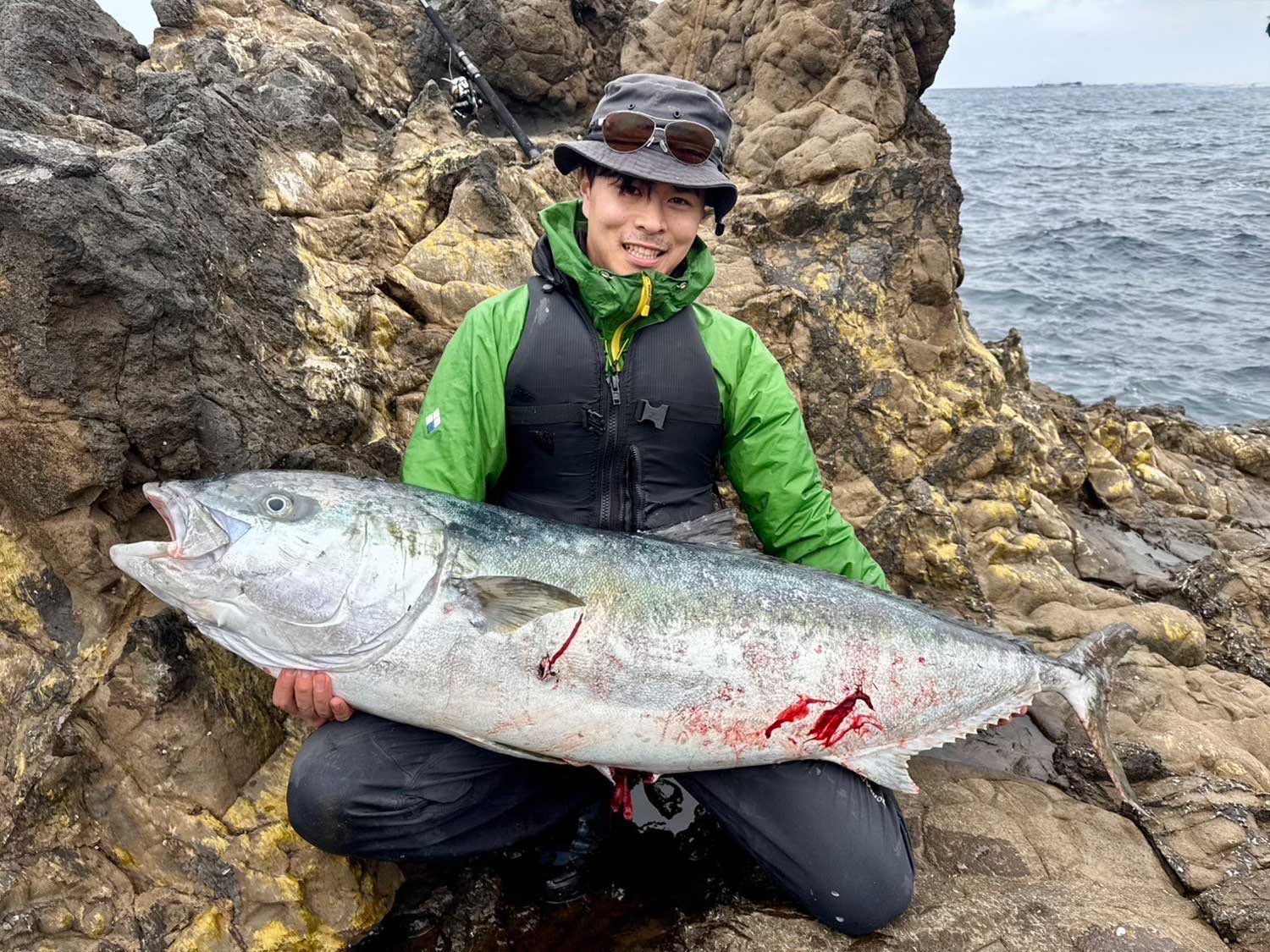 釣り上げたヒラマサ151cmを膝に乗せて抱え、笑顔の中川陸帆様