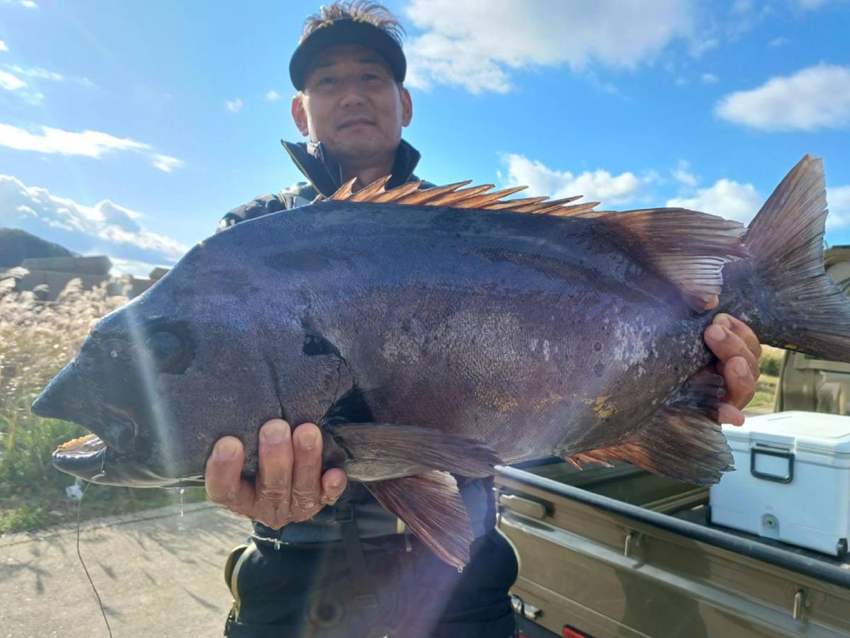 釣り上げた大物銀ワサを両手に持ち、微笑む早田