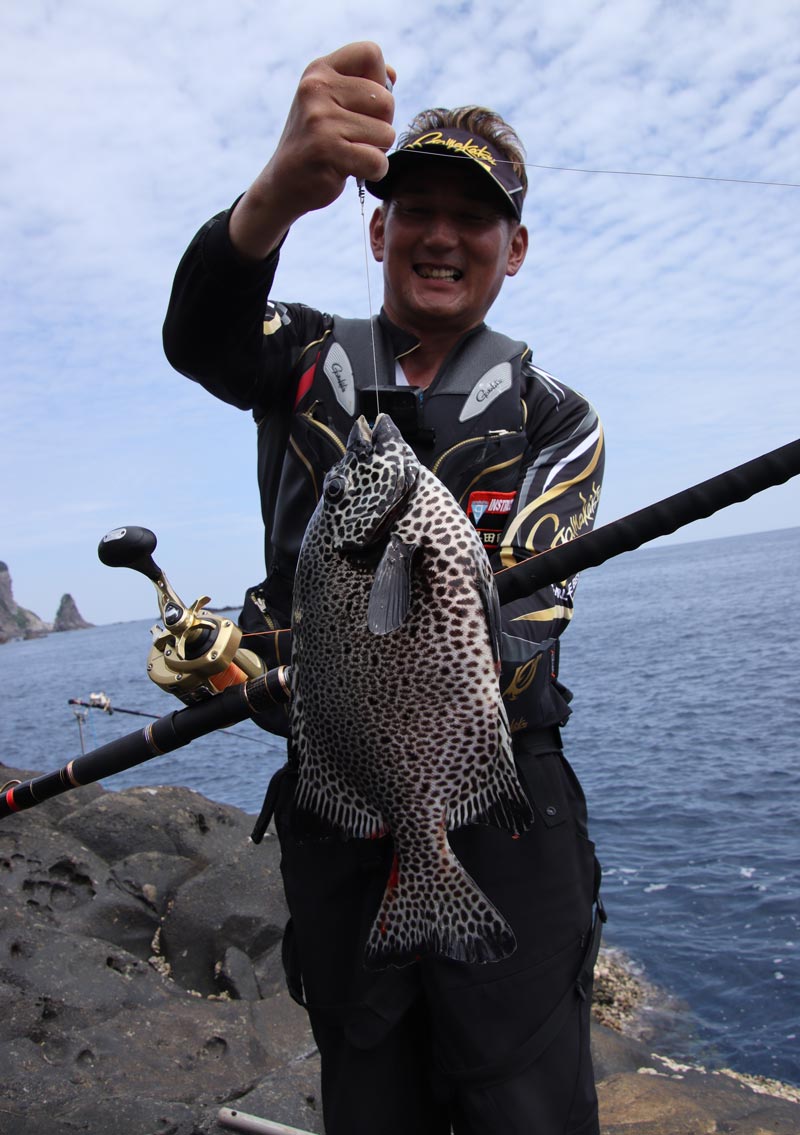 釣り上げたイシガキダイを手に、笑顔の早田