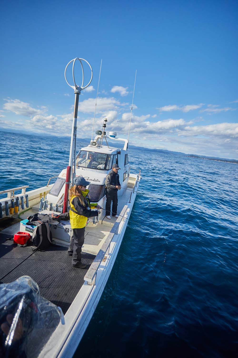 沖合の船上で釣りを楽しむ人々
