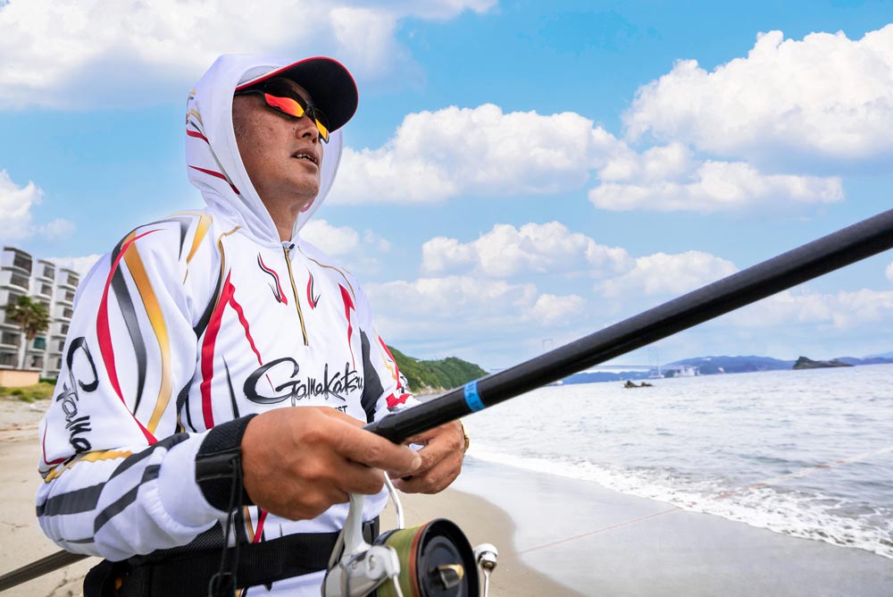 プリントジップシャツフーディを着用する矢野。沖を見つめ機会を窺う。