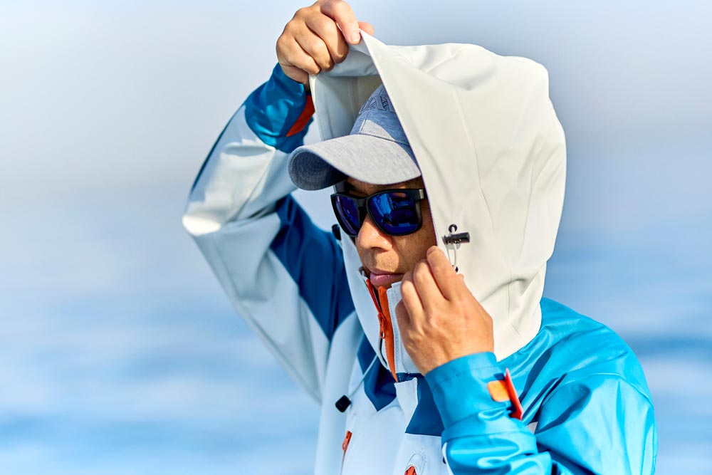 レインスーツのフードを被る男性