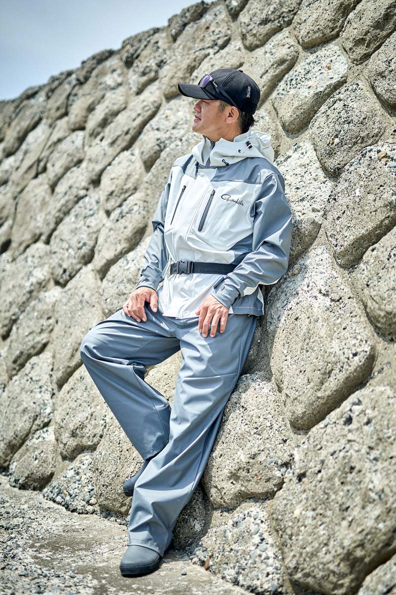 ホワイト/グレーカラーのレインスーツを着用した男性モデル