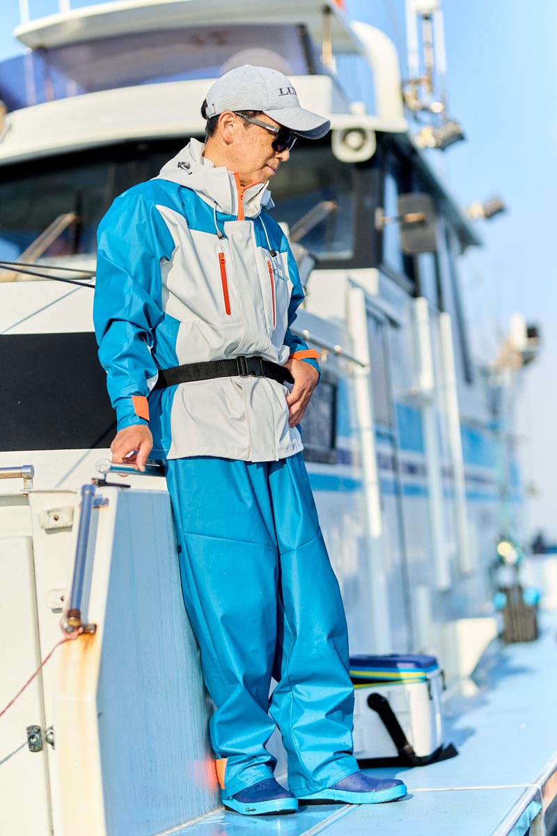 ホワイト/ブルーカラーのレインスーツを着用した男性モデル