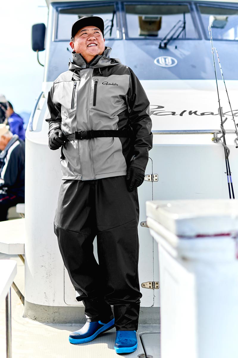 グレー/ブラックカラーのレインスーツを着用した男性モデル