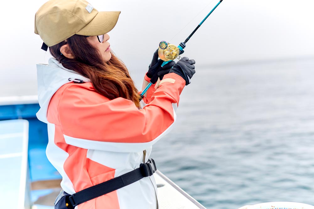釣りを楽しむ、レインスーツを着用した女性