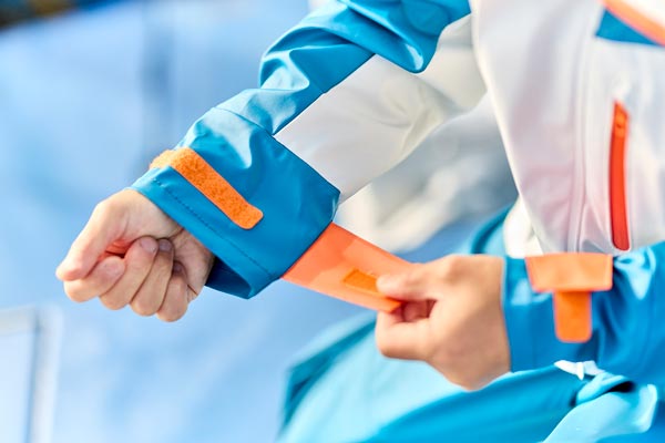 手首の袖口部分にある、面ファスナーをつける様子