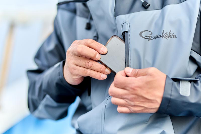 ジャケットの胸元ポケットに、スマートフォンを収納する様子