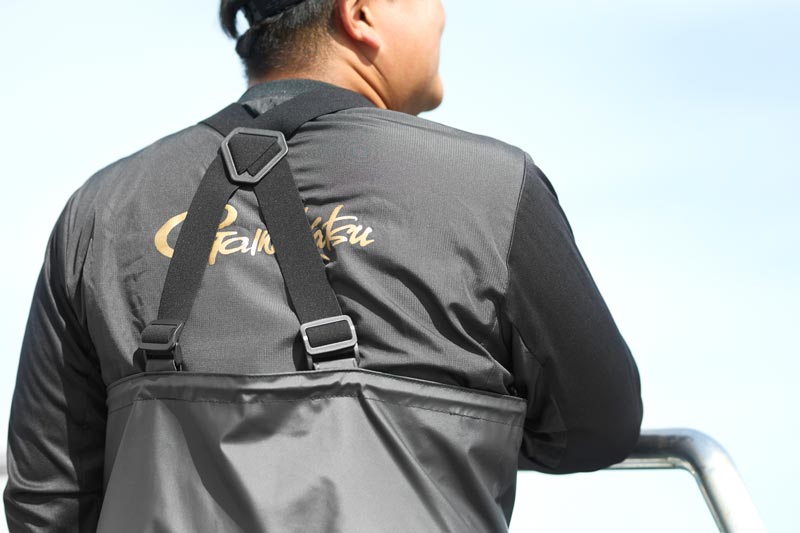 後ろを向いている男性。サロペットパンツの背面サスペンダーがよく見える