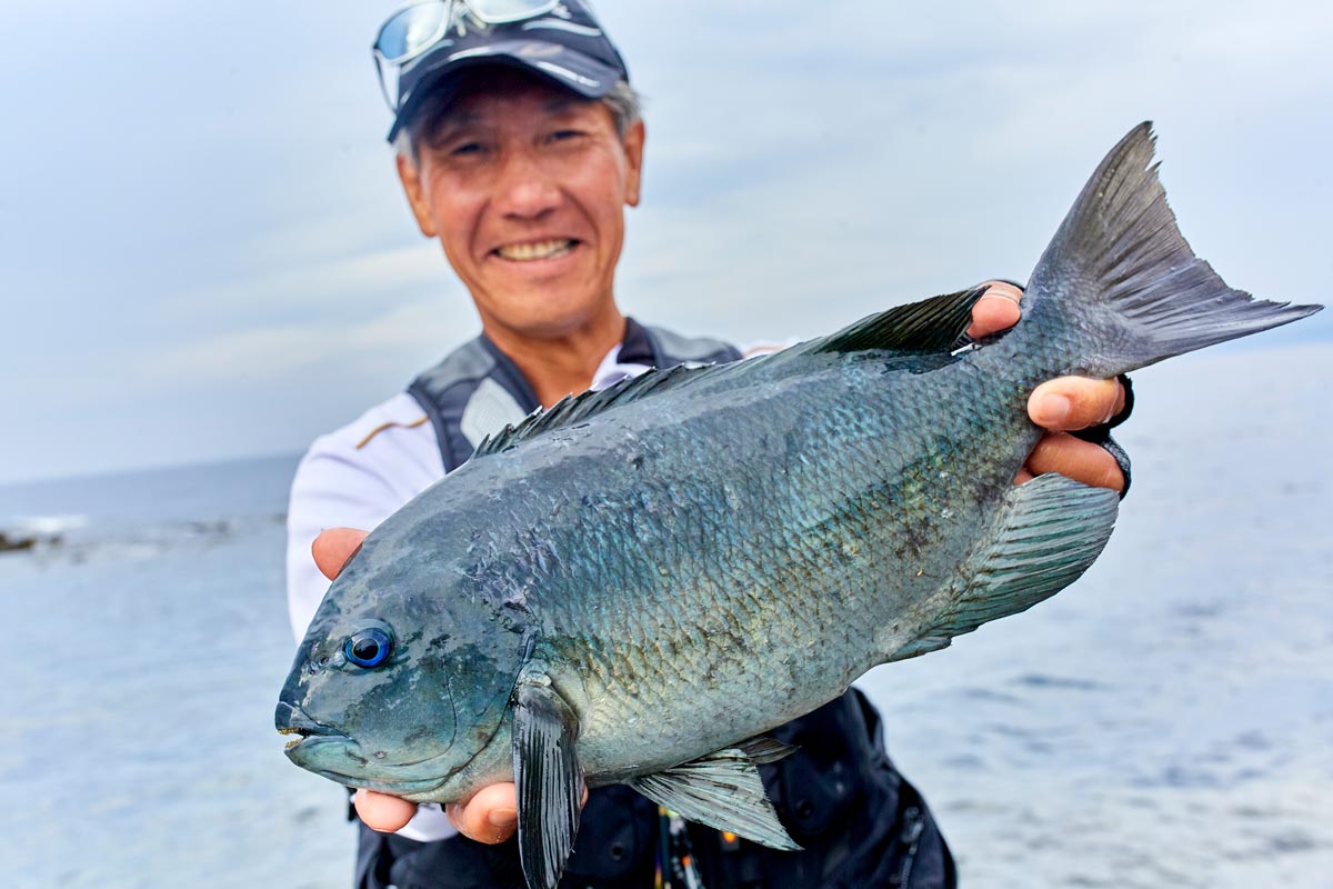 釣り上げた37.5cmの口太グレを両手に持ち、笑顔を見せる久保野