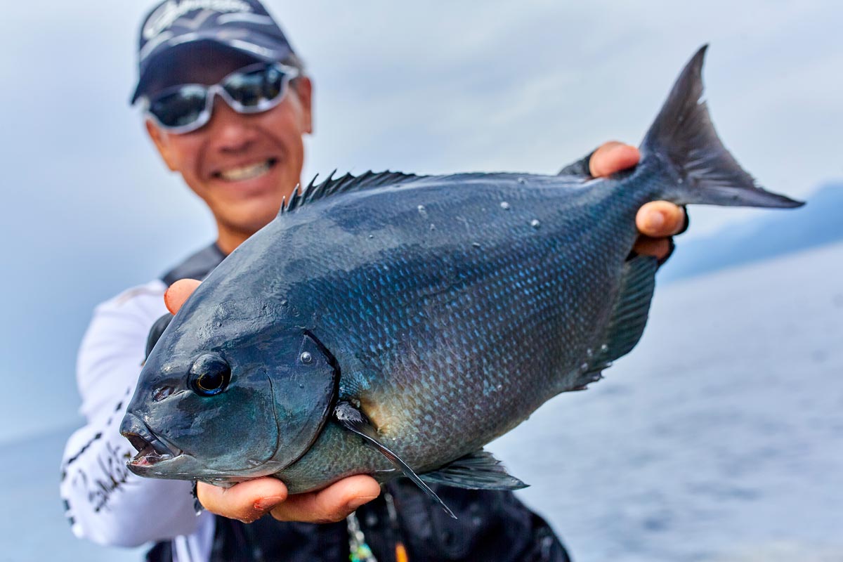 釣り上げた44cmの尾長グレを両手に持ち、笑顔を見せる久保野