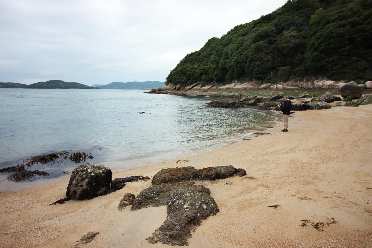 六口島の船着き付近の浜で釣りをする藤原