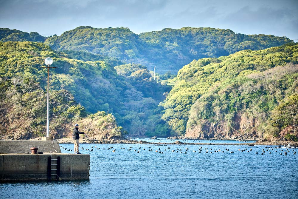 堤防で釣りを楽しむ藤原の様子を引きで収めた写真