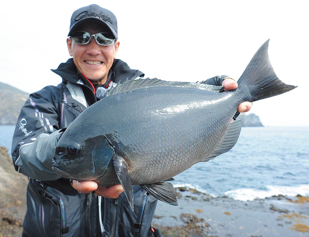 42cmの尾長グレを両手に持ち、笑顔を見せる久保野