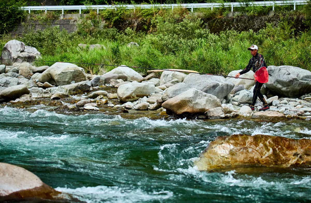 流れの激しい渓流で釣りをする廣岡
