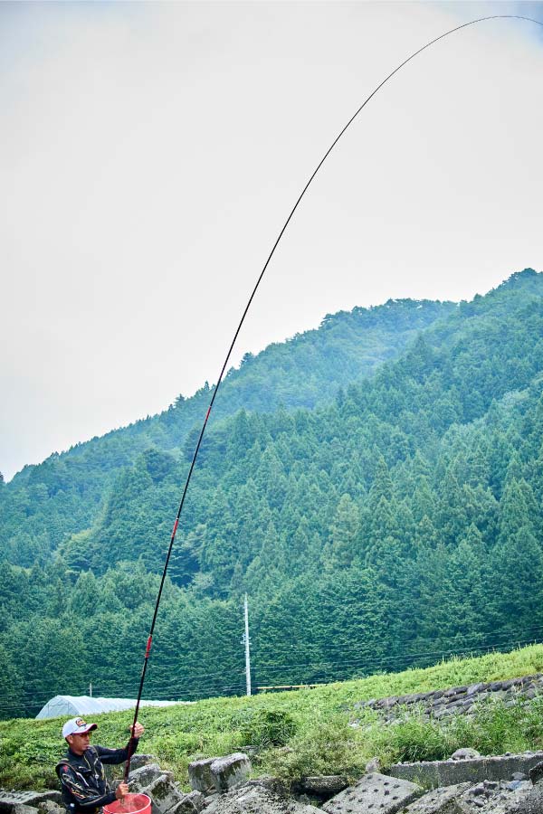 竿を立てて魚とやり取りする廣岡