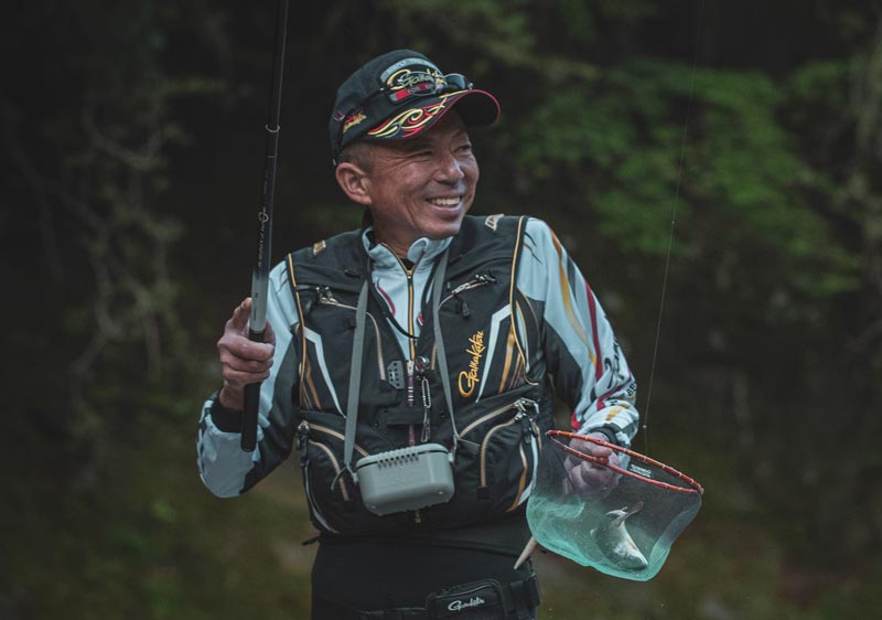 竿とアマゴが入った網を手に、満面の笑みを浮かべる廣岡