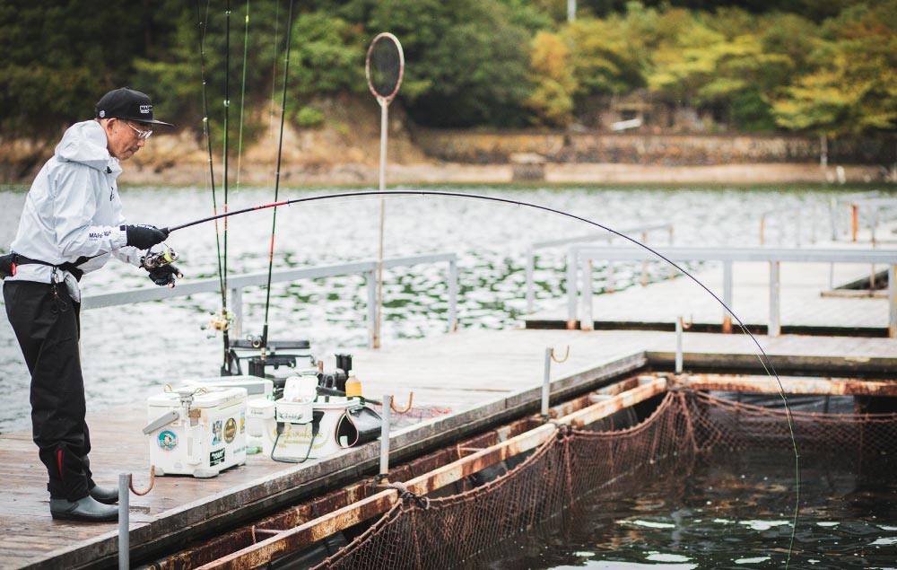 弧を描く竿を操作し、魚とやりとりする林