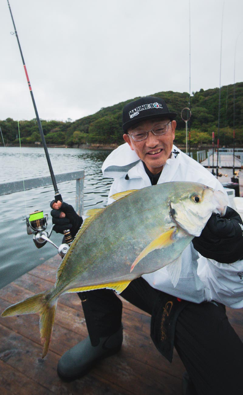 釣り上げた大型のシマアジを手に笑顔の林