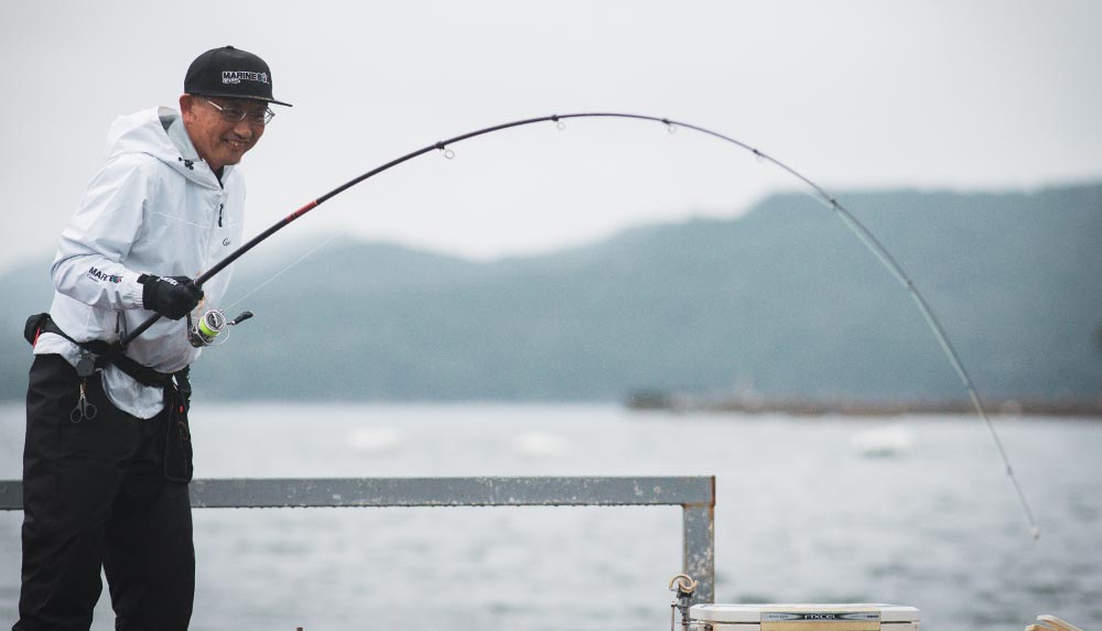 弧を描く竿を操作しつつ、満面の笑顔を見せる林