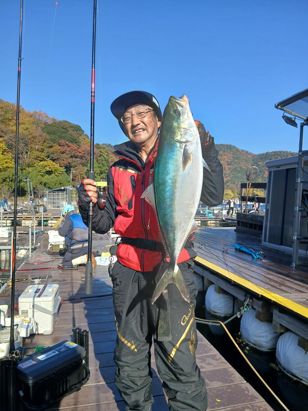 コアスペック3を右手に、釣り上げた青物魚を左手に持ち、笑顔の林