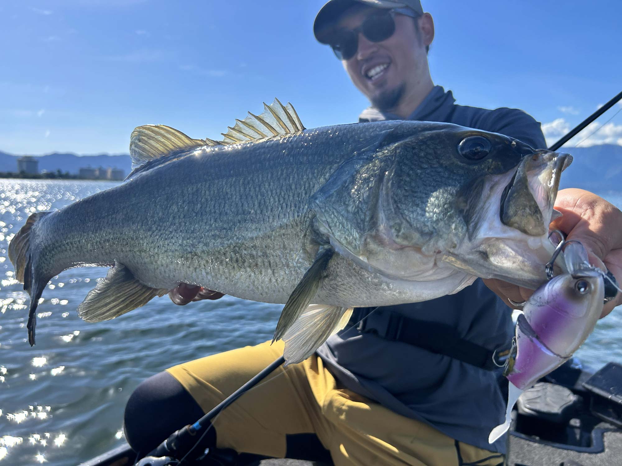 釣り上げた魚を両手に持ち笑顔の赤松