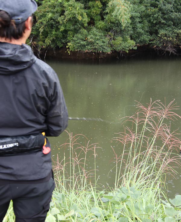 竿を持ち、アタリを待つ赤松の後ろ姿