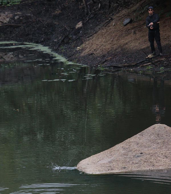 竿を操作する赤松。ルアー仕掛けがある付近からは水飛沫が舞う