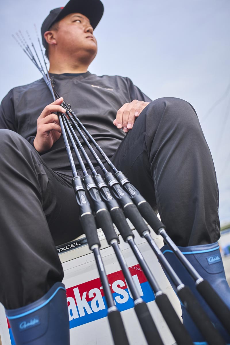 座り、立てかけるようにTTフリーク5機種を手に持つ中山