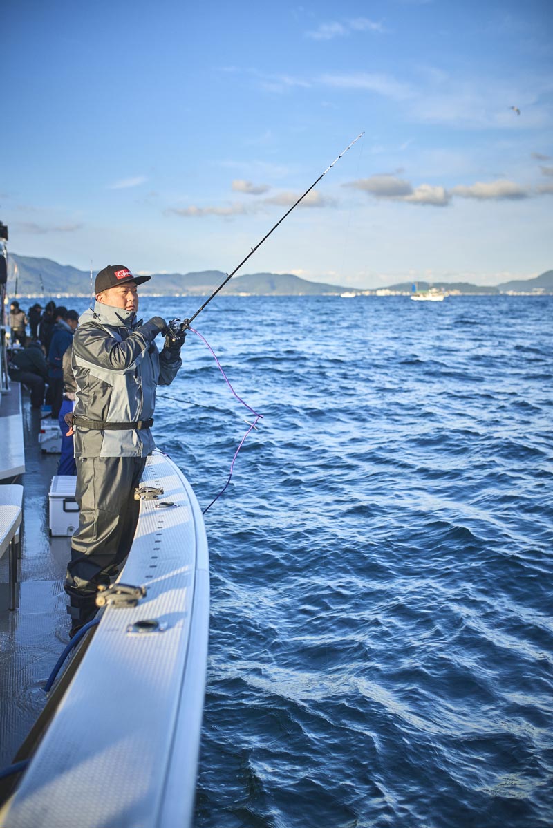 船上にて。海の様子を伺いながら、竿を操作する中山