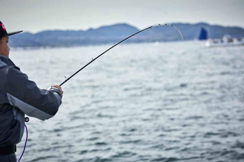 弧を描く竿を引く中山