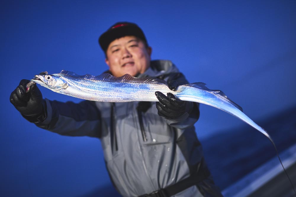 釣り上げたタチウオを両手で持つ中山