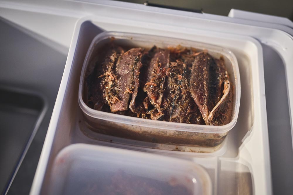 タッパーに入れられた、用意した魚の開きエサ