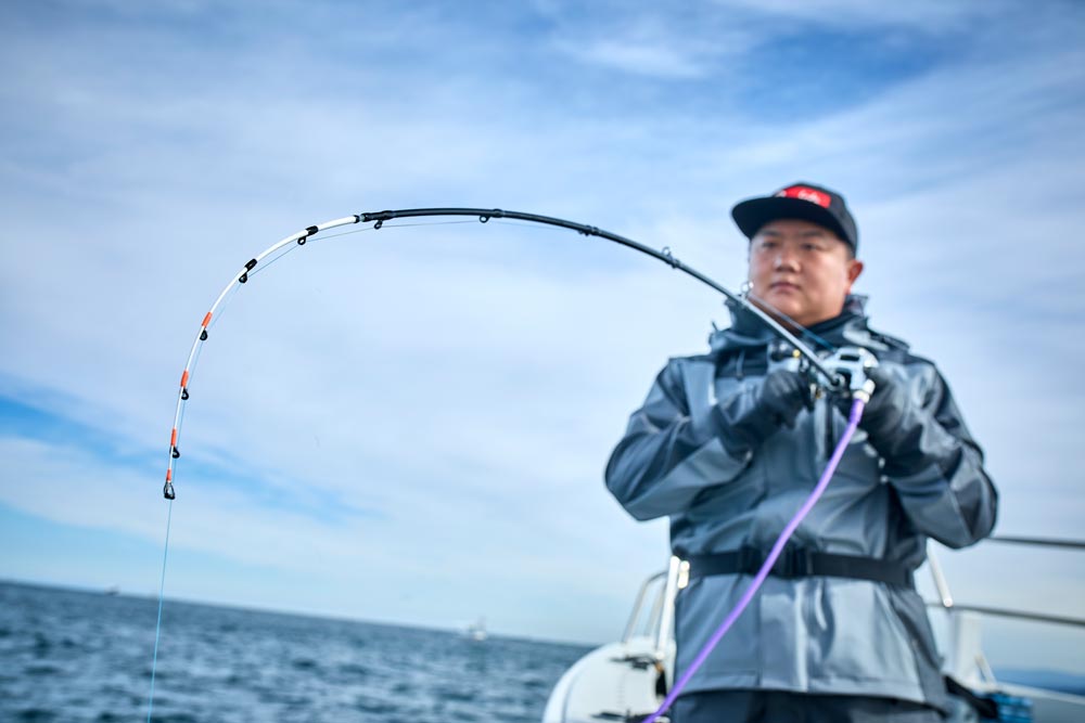 大きく弧を描く竿を操作する中山