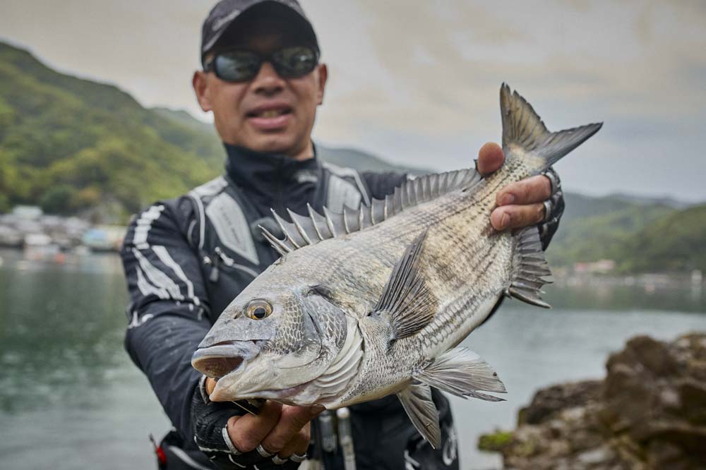 釣り上げたチヌを両手に持つ沖永