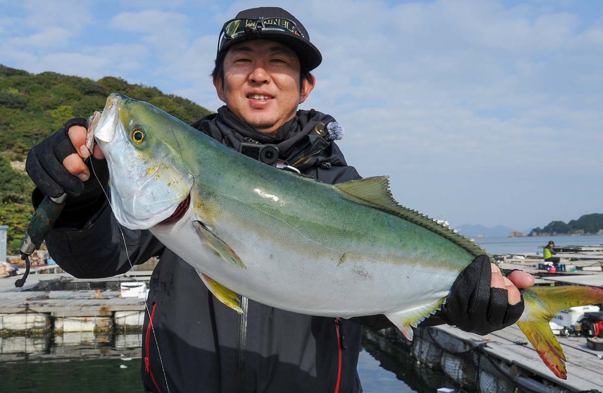 釣り上げた大物の青物魚を両手に持つ中嶋