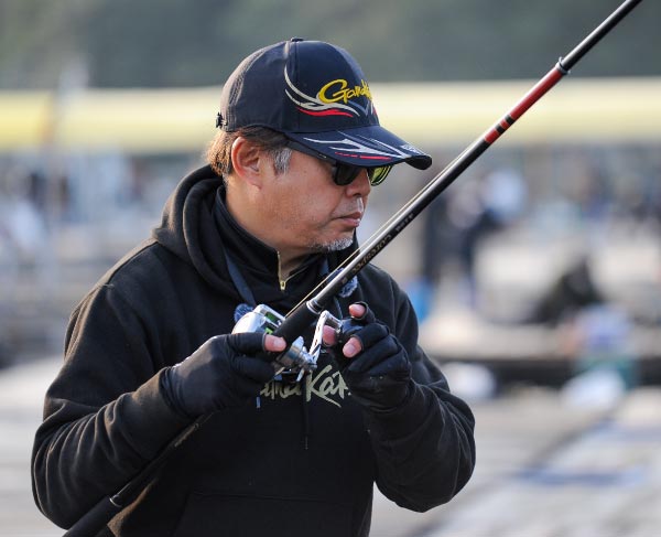 イケスを見つめながら竿を操作する沖長