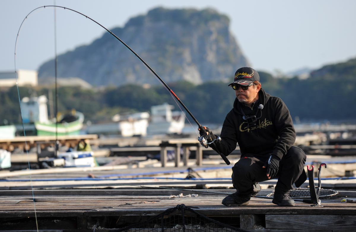 大きな弧を描く竿を片手で引く沖長