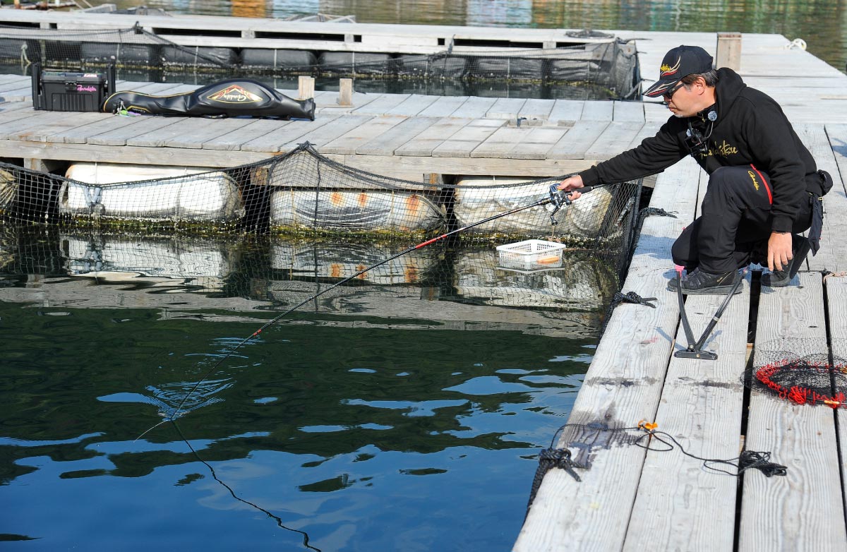 しゃがみこみ、竿を片手で操作する沖長