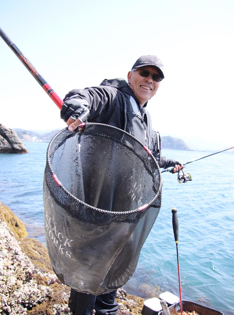 チヌが収まったタモを見せながら、満面の笑顔を見せる中西
