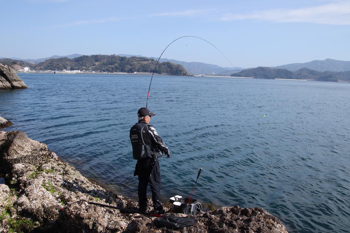 大きな弧を描く竿を操作する中西