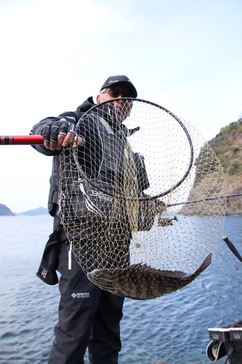 チヌが収まったタモを見せながら、笑顔を見せる中西