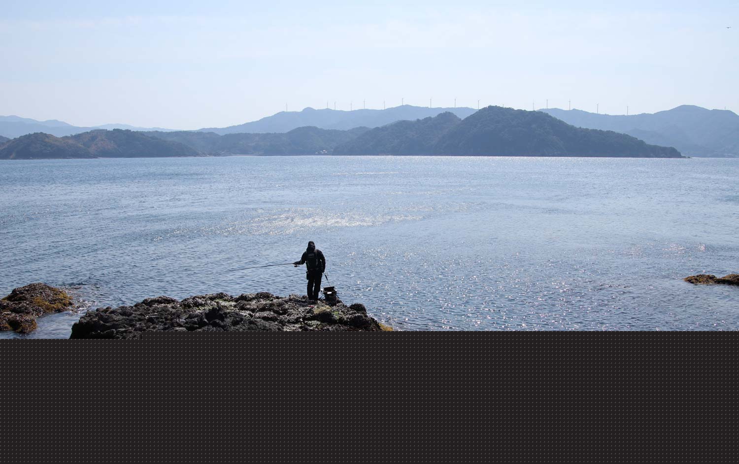 磯の先端で釣りをしている中西を、空から捉えた写真