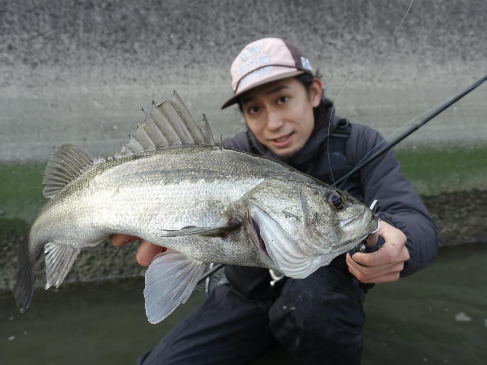 釣り上げたシーバスを両手に持ち掲げる黒神