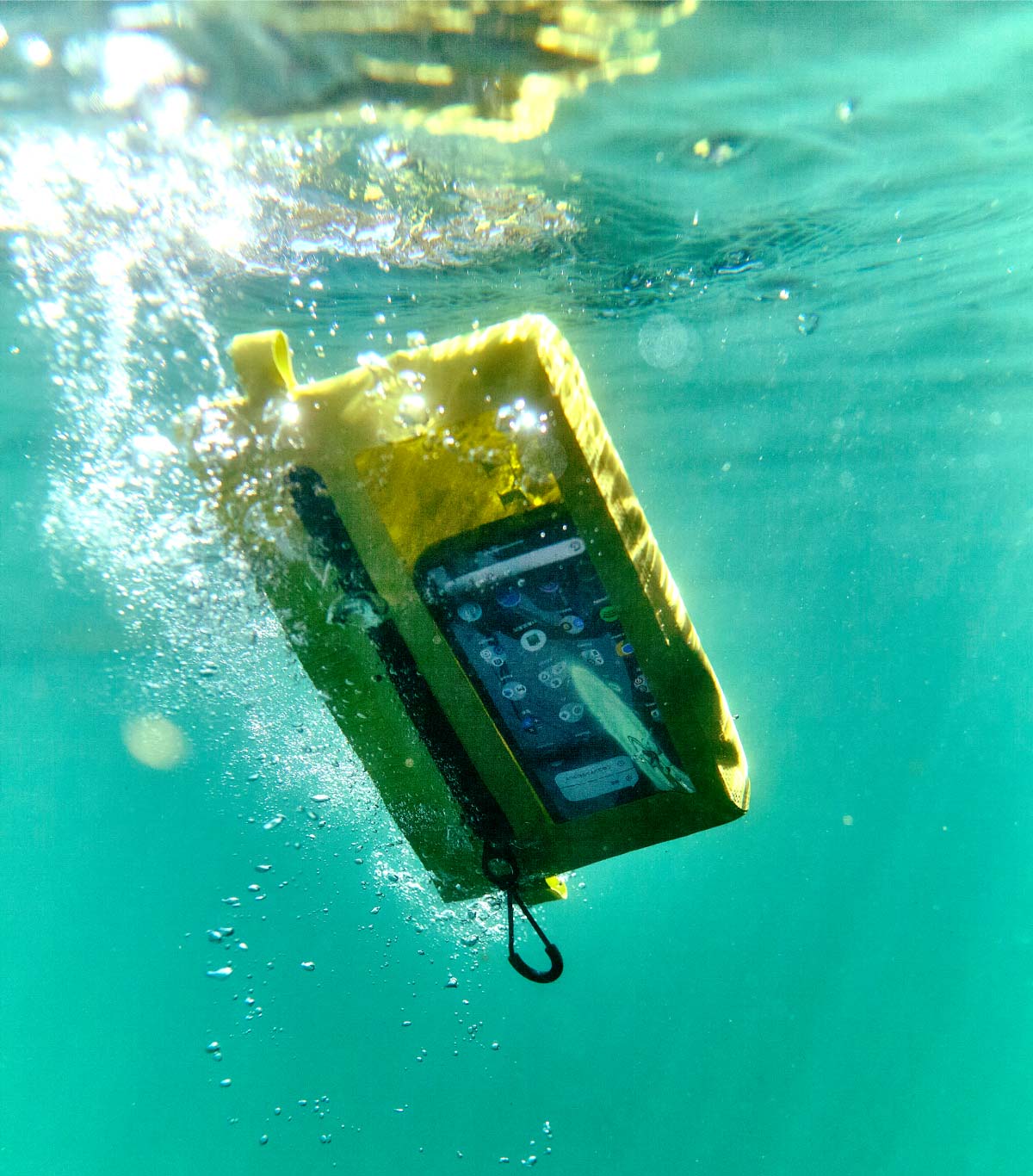 スマートフォンを入れた防水ポーチが水中に入っている様子