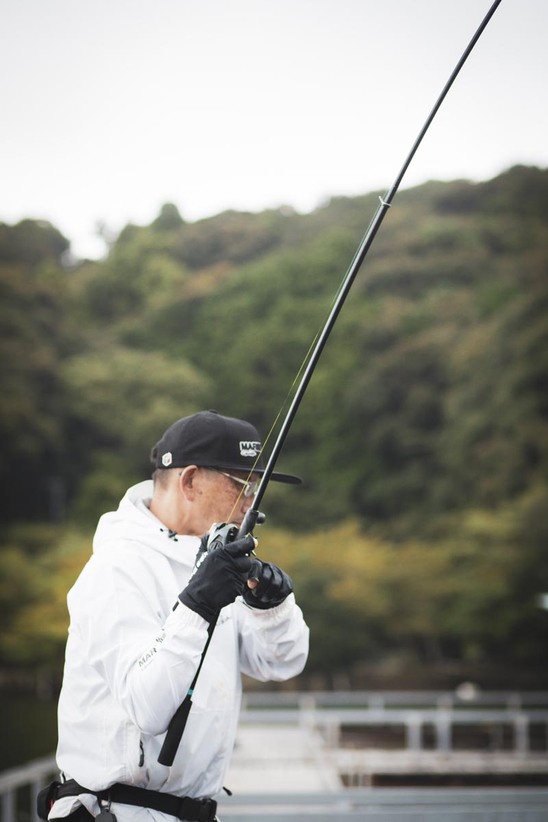 竿を立て、リールを操作する男性