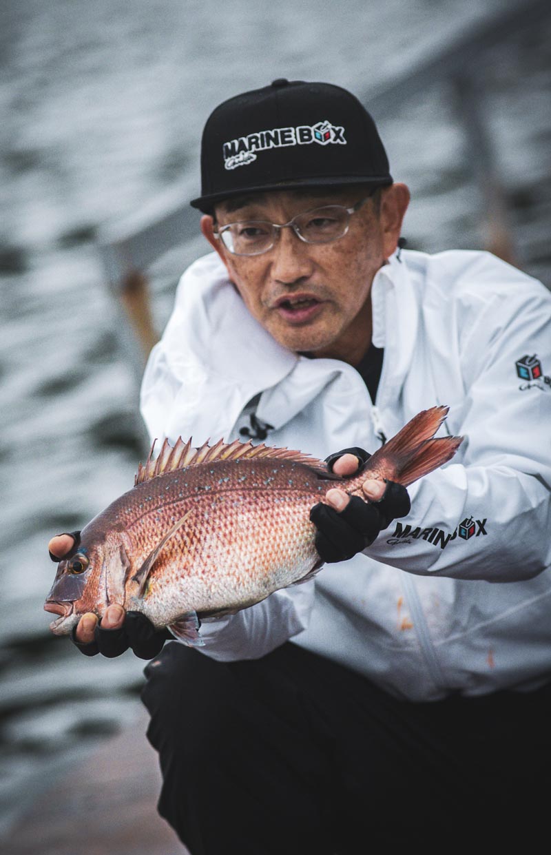 釣り上げた真鯛を両手に持つ男性
